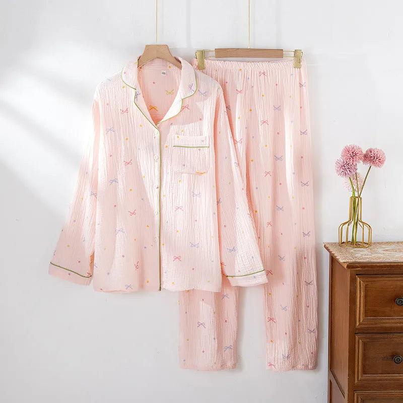 Women's pink cotton pajama set with long sleeves and full-length trousers on hanger
