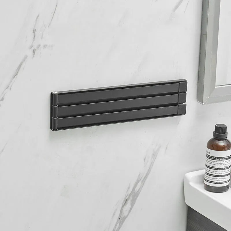 Nordic style black folding towel rack mounted on a bathroom wall