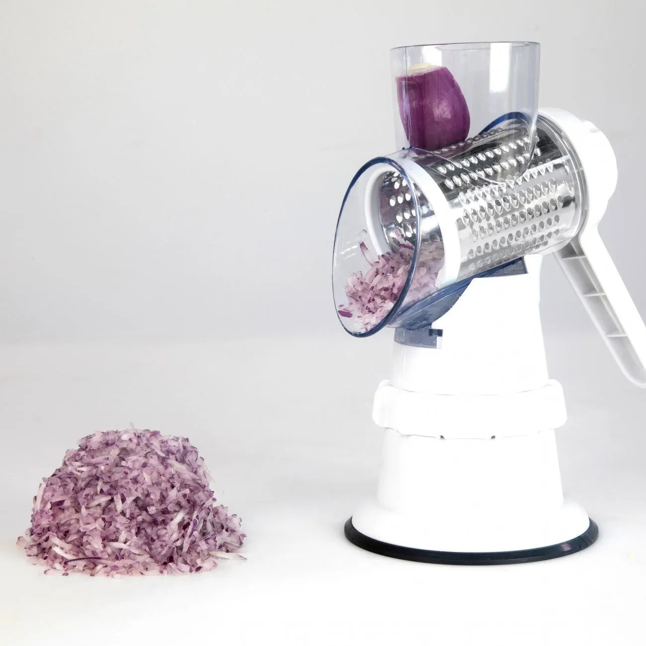White plastic manual 3-in-1 vegetable slicer grater with stainless steel blades on a kitchen counter.
