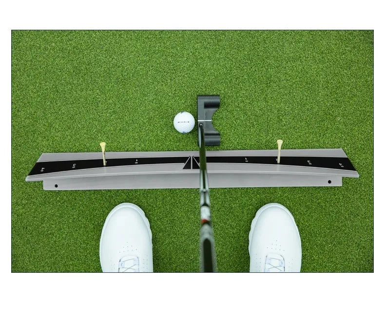 Close-up of an adjustable PVC golf putter trajectory balance simulator on a flat surface.