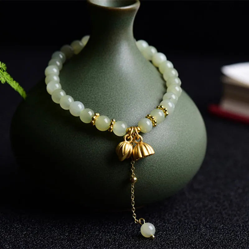 Two Shihuan natural Hetian jade bracelet with 6mm beads, fu charm, and lotus motif on a wrist.