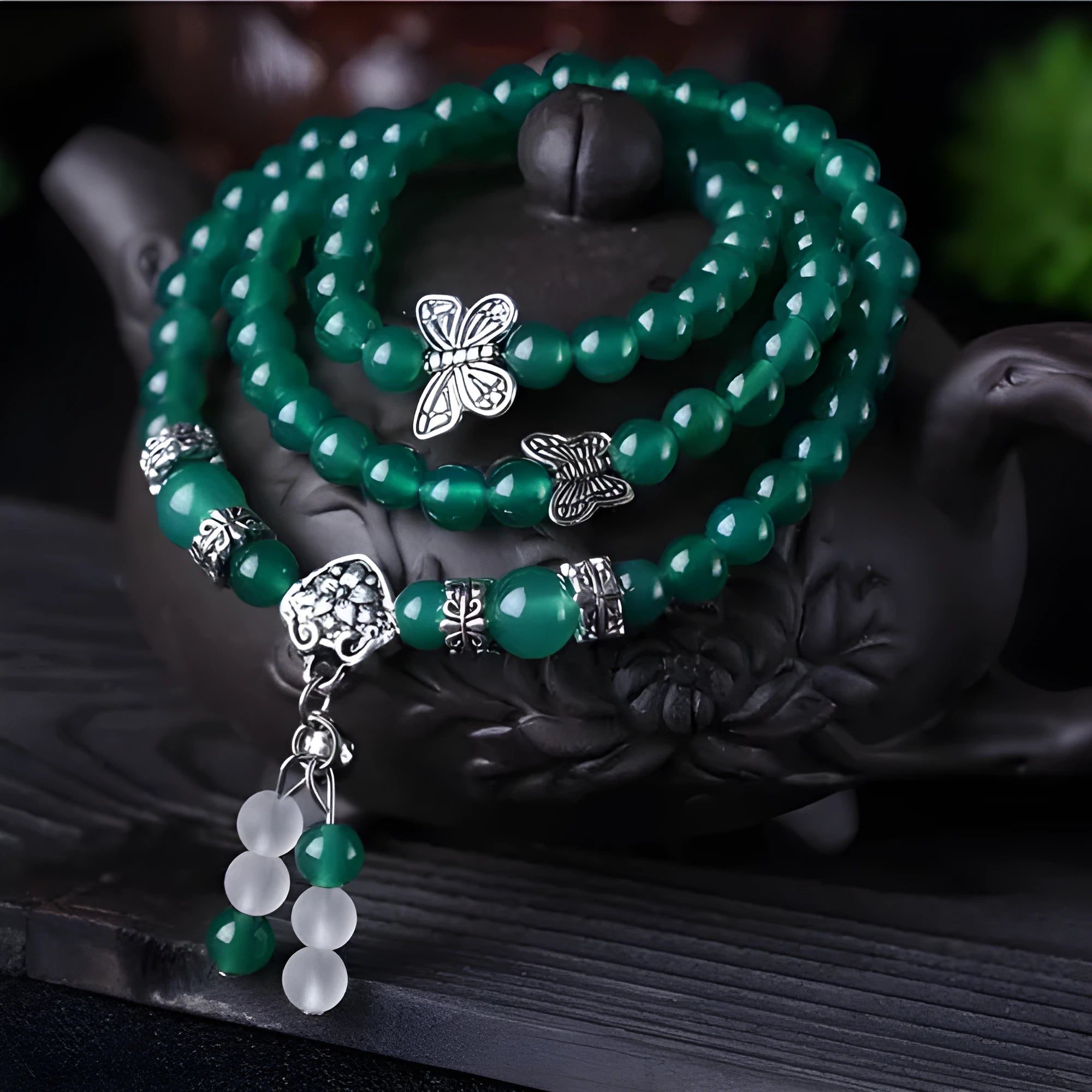 Close-up of a women's multi-strand bracelet with green agate beads on a wrist.