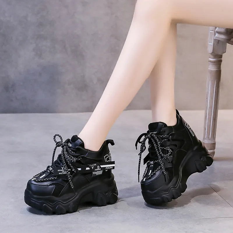 White and black women's low-top platform sports shoes with a cross strap and mesh upper.