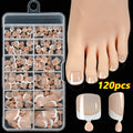 120 piece set of nude French white tip artificial toenails in nine shades, showing square short shape.