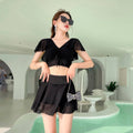 Women's solid colour two-piece swimsuit set with a top and split skirt.
