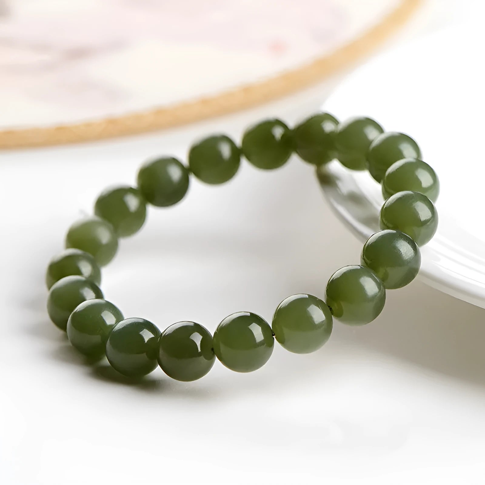 Polished Hetian jade ball bead bracelet in clear colour on wrist, showing spherical beads.