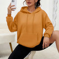 Women's loose grey sweatshirt with a front pocket and drawstring waist, worn with jeans.