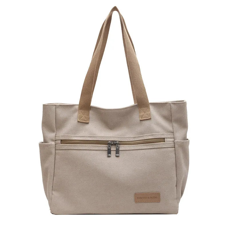 Canvas shoulder bag for women in khaki with stitching detail, open front pocket, and double shoulder straps