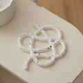 A solid colour ceramic heat proof mat with an irregular shape on a dining table.