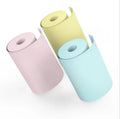 Bluetooth mini thermal photo printer in pink with USB cable and paper rolls on a white background