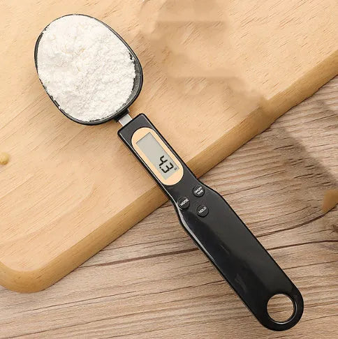 White digital kitchen scale with LCD display and spoon-shaped weighing surface for precise ingredient measurements