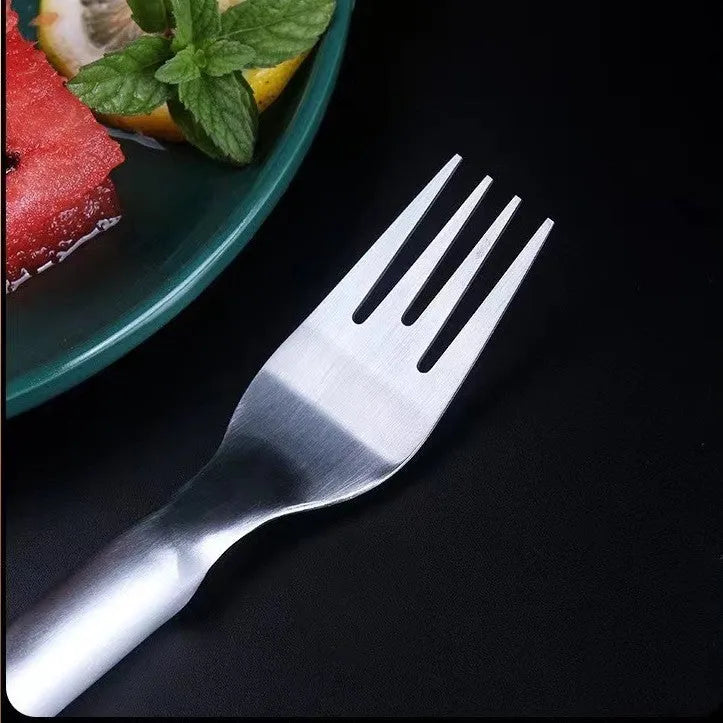 Silver stainless steel watermelon slicer and serving fork on a kitchen counter