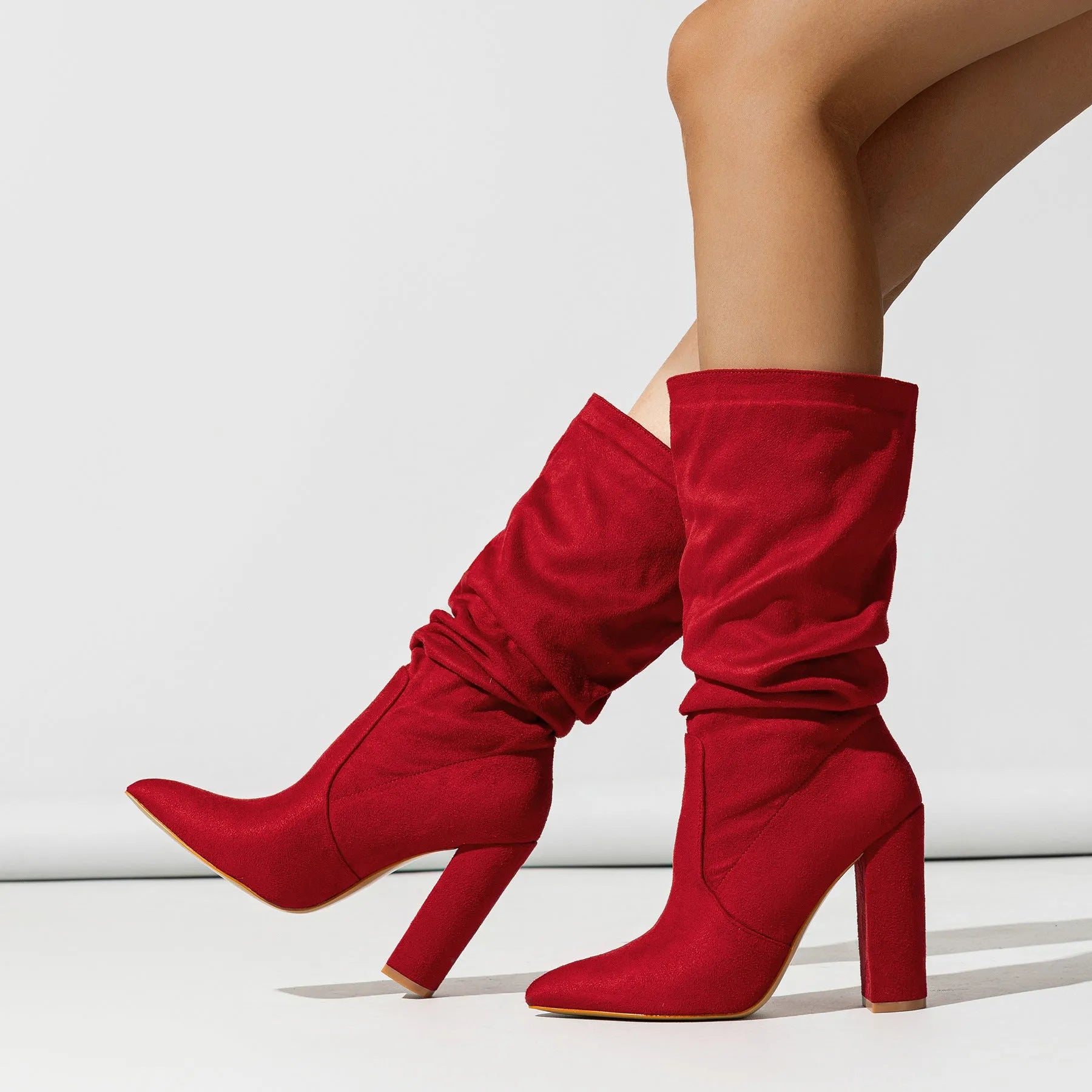 Black suede women's boots with a chunky high heel and pointed toe, shown on a mid-calf length.