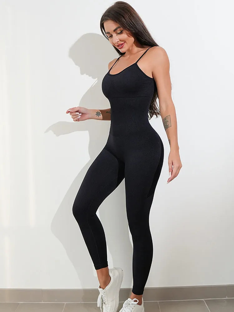 Woman wearing a black sleeveless unitard jumpsuit with spaghetti straps and a backless design.