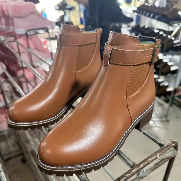 Black ankle boots with round toe and belt buckle decoration, showing rubber sole and waterproof artificial PU upper