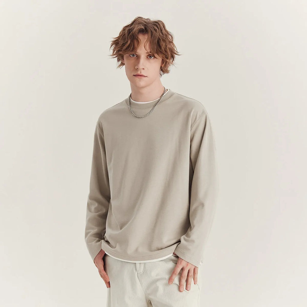 Man wearing a loose-fit long-sleeved grey cotton blend T-shirt with a round neck.