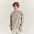 Man wearing a loose-fit long-sleeved grey cotton blend T-shirt with a round neck.