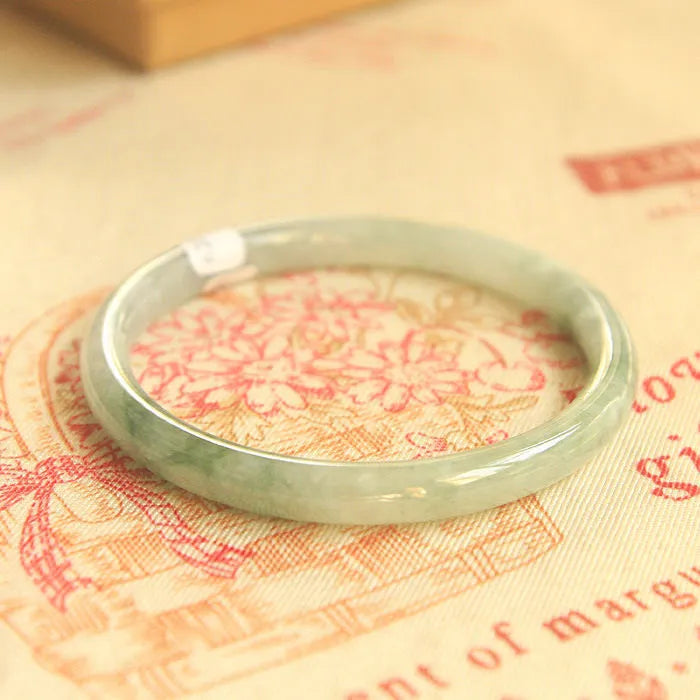 Green jade waxy finish geometric Chinese style bracelet shown on wrist, 10mm width.