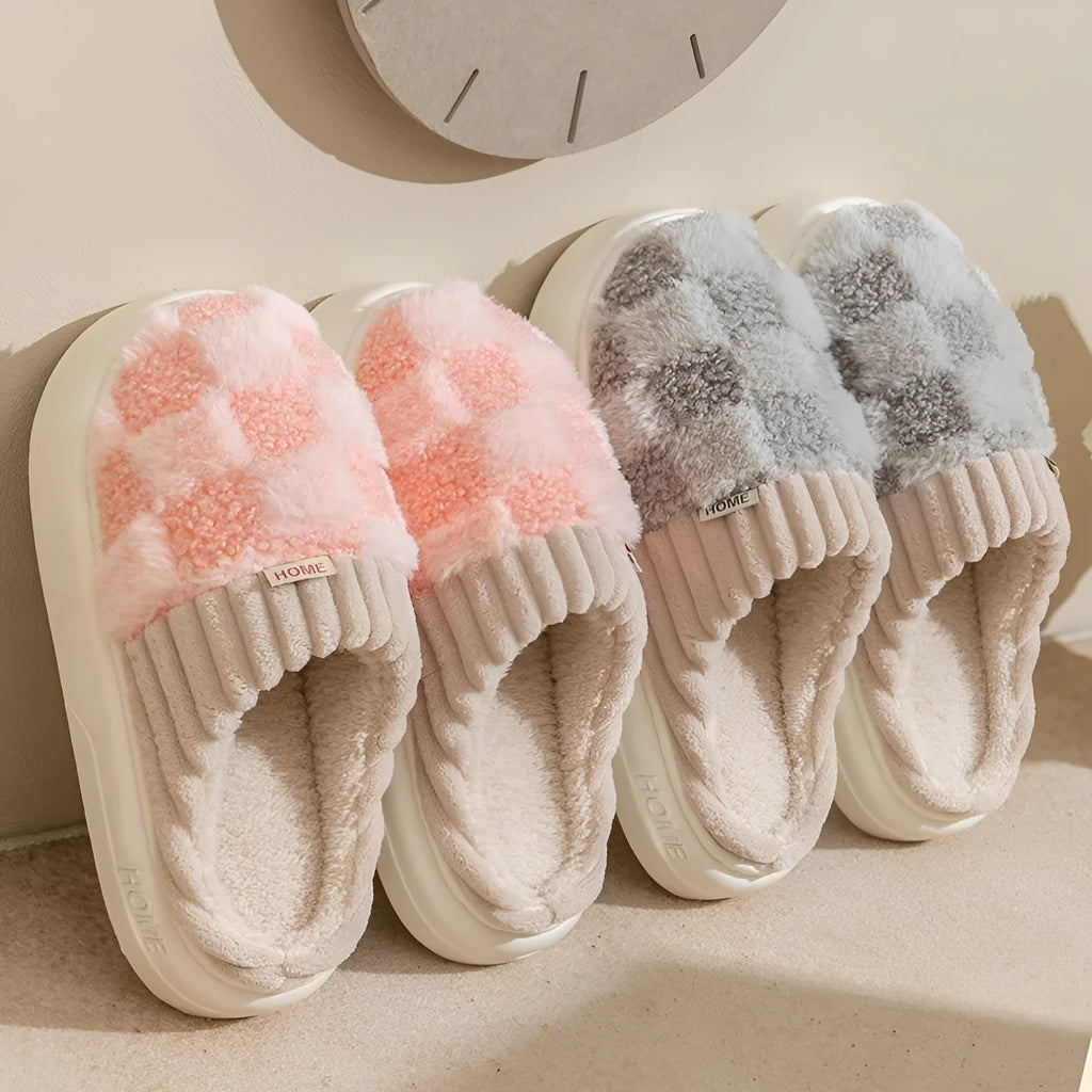 Plaid pattern women's slippers with plush lining and a light-coloured non-slip PVC sole, shown in a grey colour option.