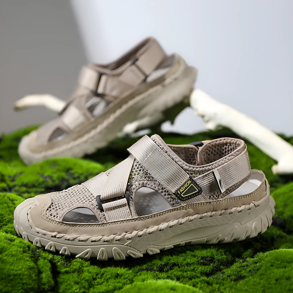 Men's grey casual sandals with a mesh lining, genuine leather upper, and an elastic band toe holder on a rubber sole.