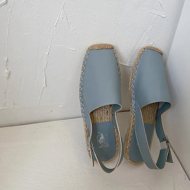 Women's beige canvas baotou flat sandals with a retro fisherman style on a plain background.