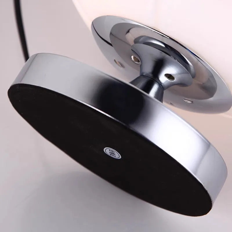 Creative football-shaped glass table lamp with dimmer switch on a desk in a modern living room