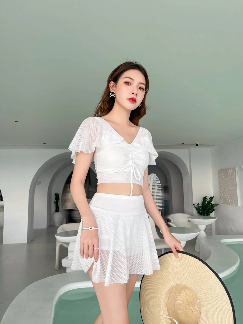 Women's solid colour two-piece swimsuit set with a top and split skirt.