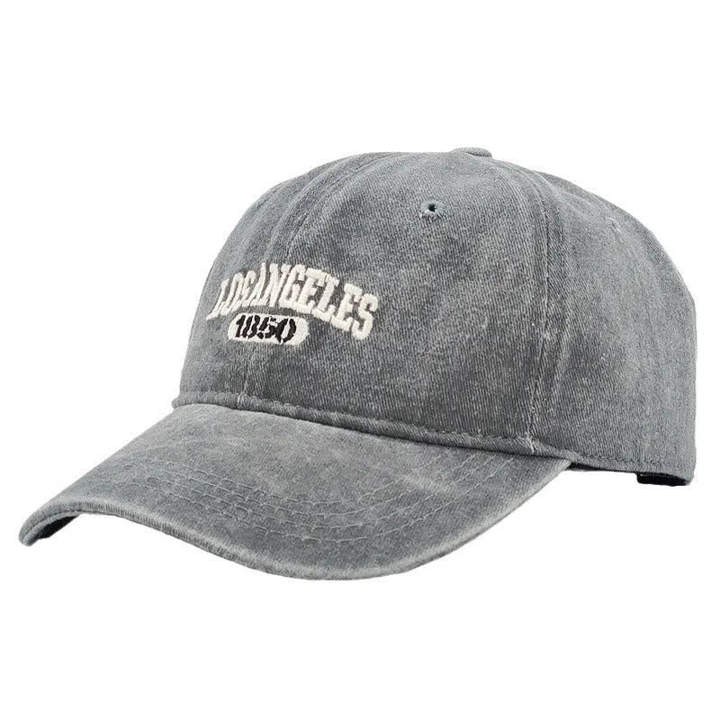 Retro distressed baseball cap with embroidered letters on the front, shown in a beige colour.