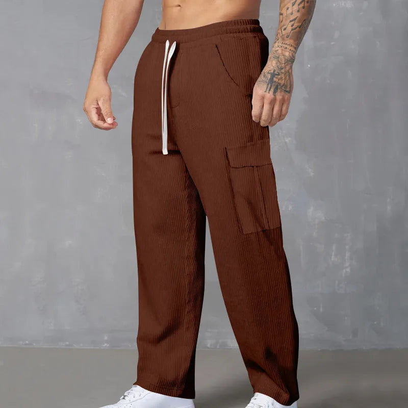 Men's navy blue corduroy cargo trousers with a straight loose leg and a drawstring waist, laid flat.
