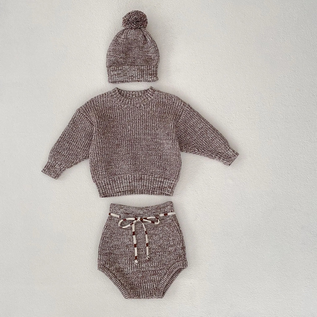 Dark brown knitted 3-piece set for infant girl with pullover blouse, pants, and fur ball hat