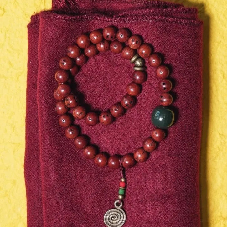 Handmade bodhi seed double circle bracelet with cartoon style on a wrist.