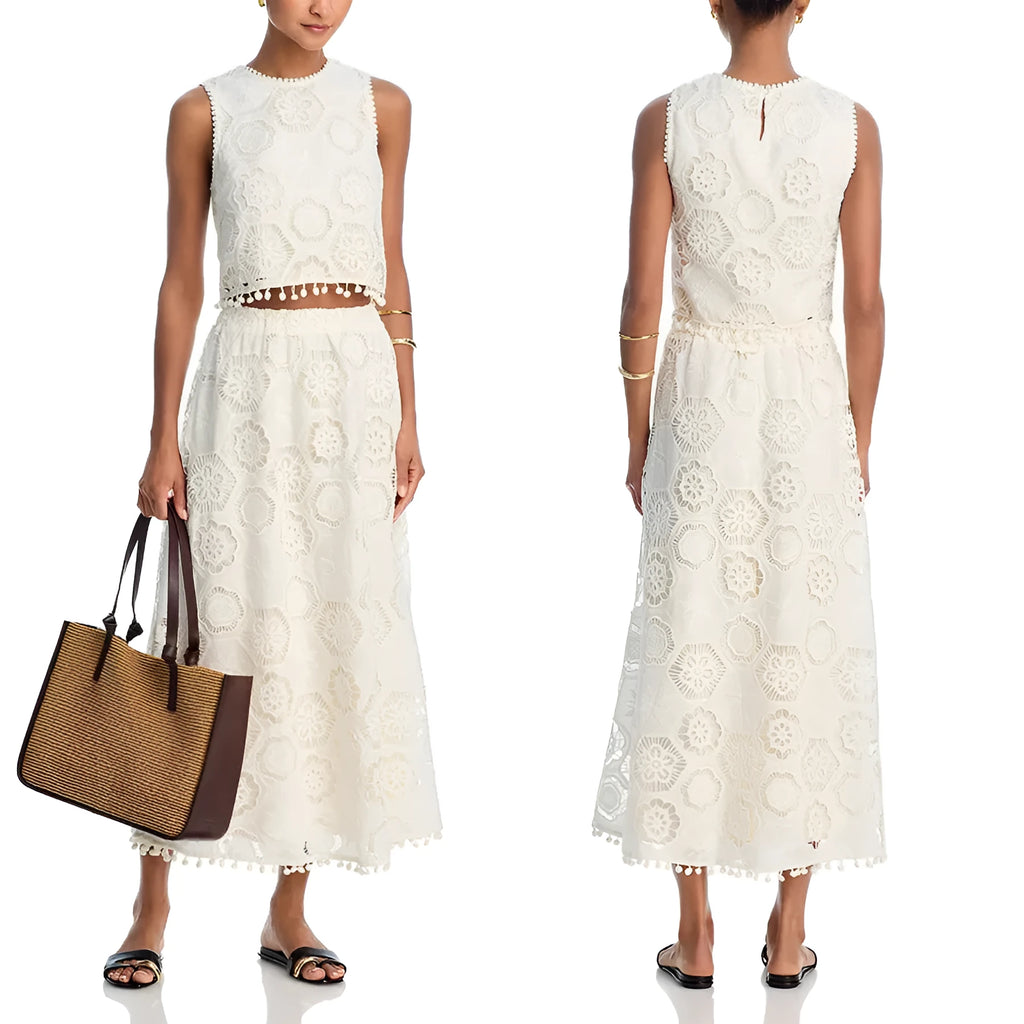 White women's sleeveless top and embroidered long skirt suit set on a hanger.
