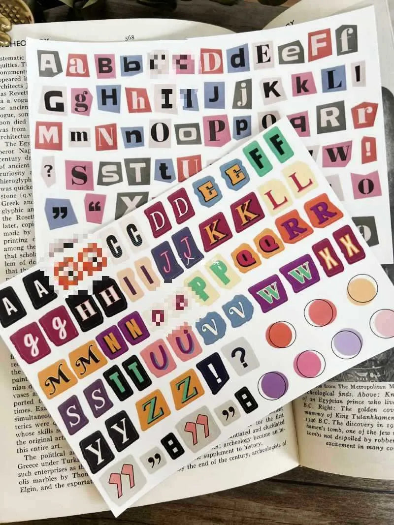 Sheets of cute printed stickers showing English letters A to Z, numbers, symbols, and weekly words like Monday and Friday.