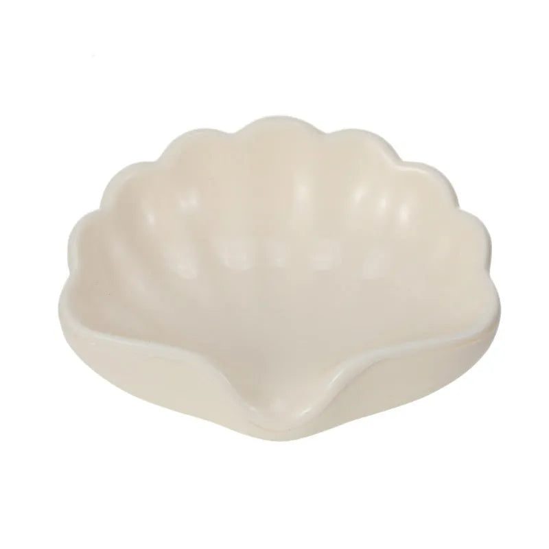 White or pink plastic shell-shaped soap dish for bathroom use