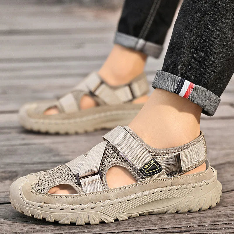 Men's grey casual sandals with a mesh lining, genuine leather upper, and an elastic band toe holder on a rubber sole.