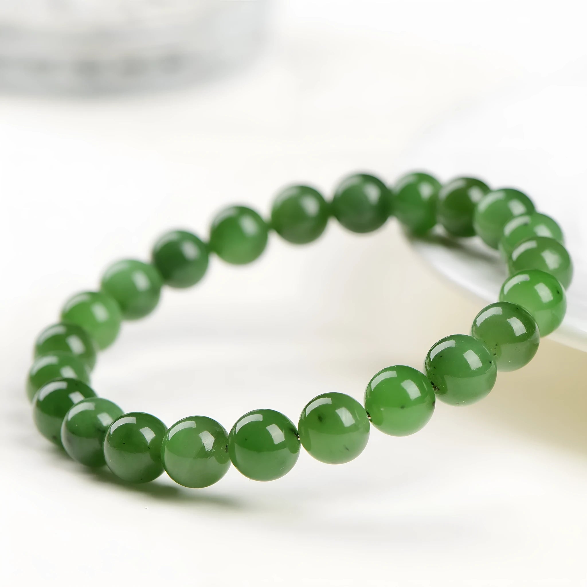 A single strand polished jasper bead bracelet in natural colours, showing different size options.