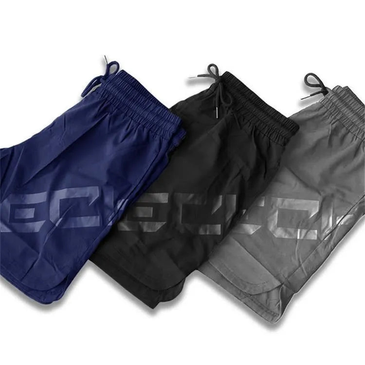 Men's black quick-drying nylon blend training shorts with elastic waist, shown in knee-length sports style.