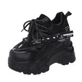 White and black women's low-top platform sports shoes with a cross strap and mesh upper.