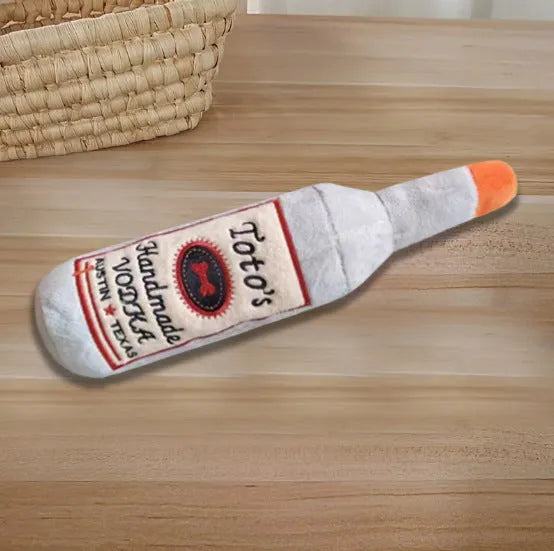 Brown plush wine bottle shaped dog toy with squeaky feature for interactive chew play