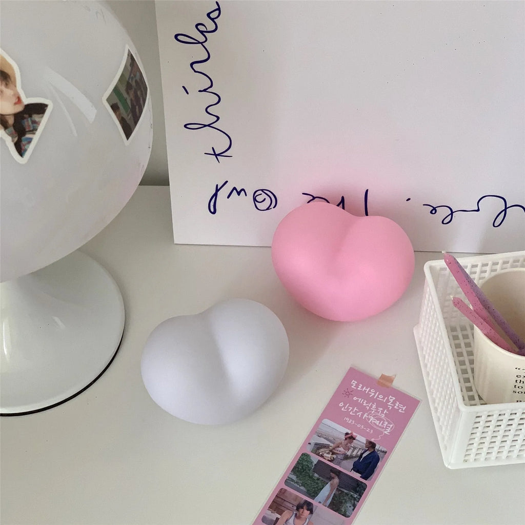 Pink and white vinyl trumpet-shaped atmosphere lamps in two sizes on a table