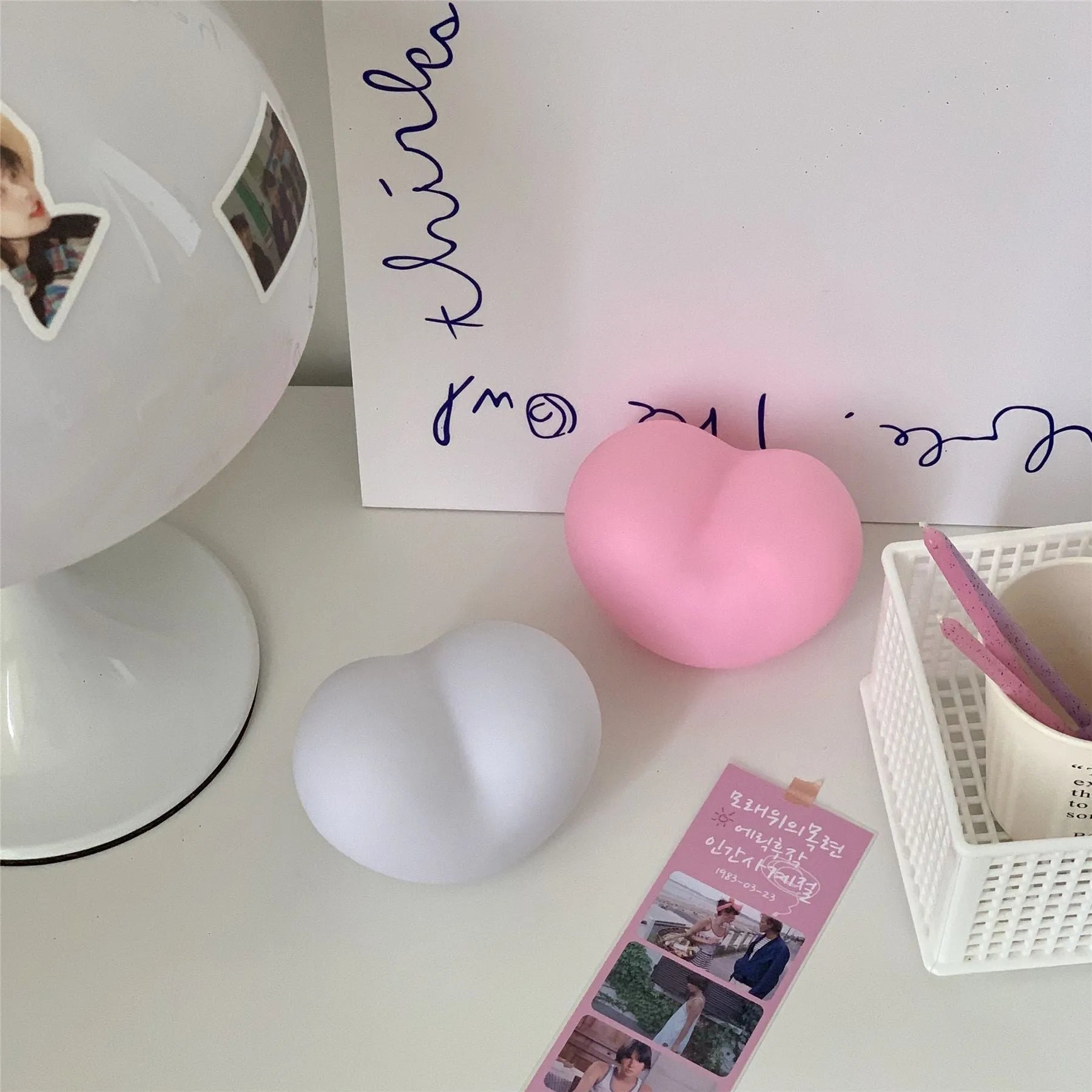 Pink and white vinyl trumpet-shaped atmosphere lamps in two sizes on a table