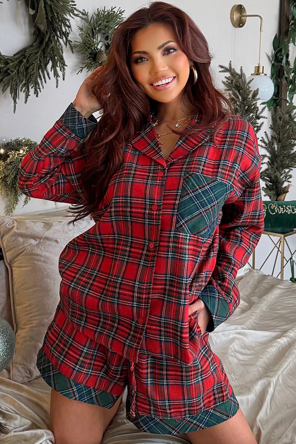 Red plaid Christmas pyjama set with long sleeve shirt and shorts on a hanger.