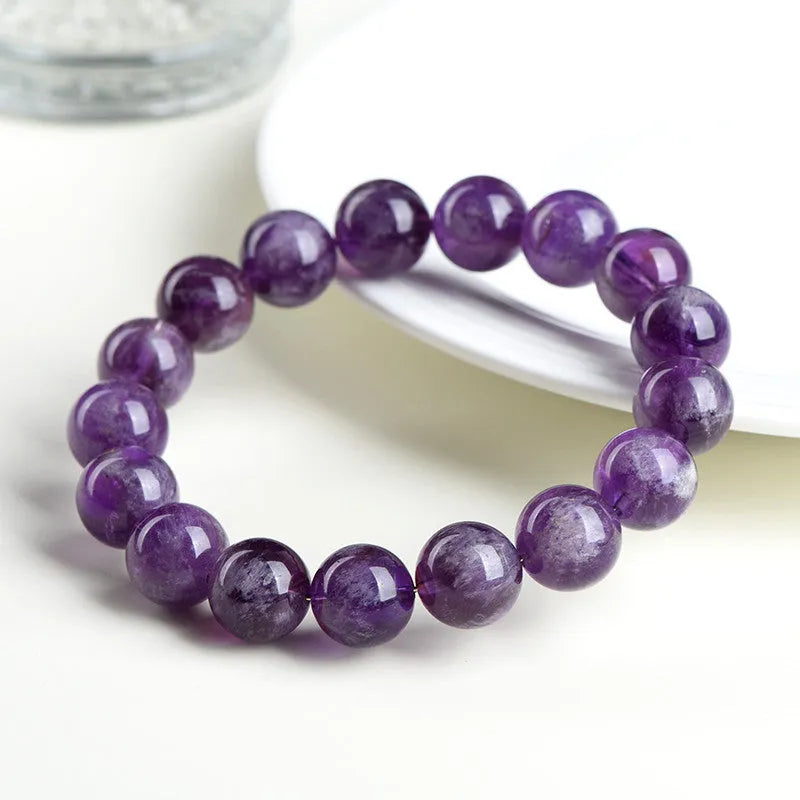 Snow Mountain Feather Amethyst crystal bracelet with scattered geometry beads and Ruyi design on a wrist.