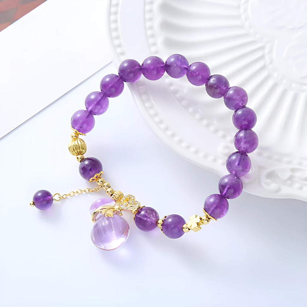 Purple amethyst bracelet with ethnic-style money bag pendant and geometric shapes on wrist