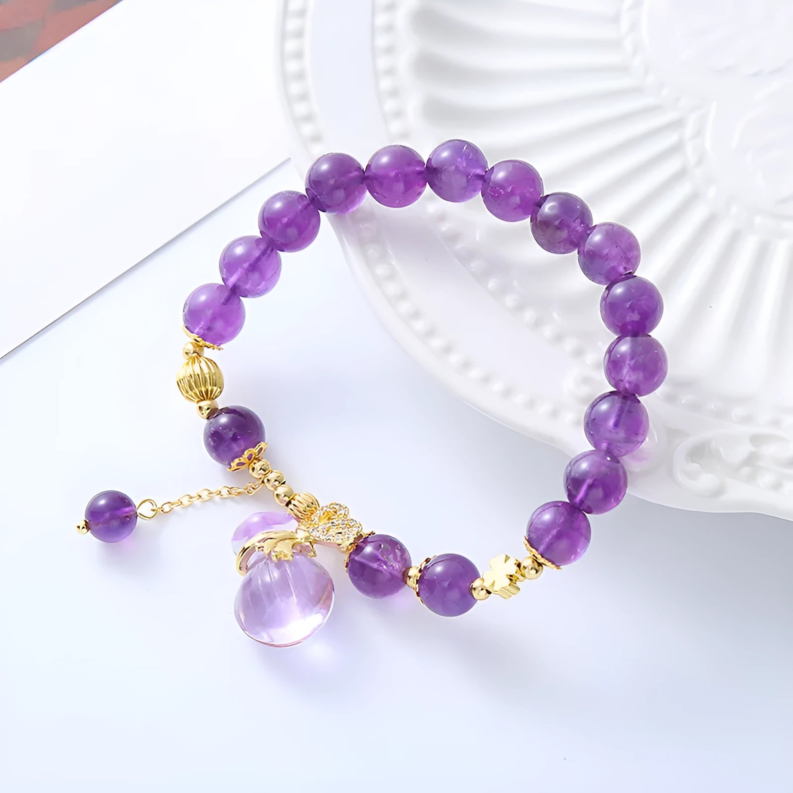 Purple amethyst bracelet with ethnic-style money bag pendant and geometric shapes on wrist
