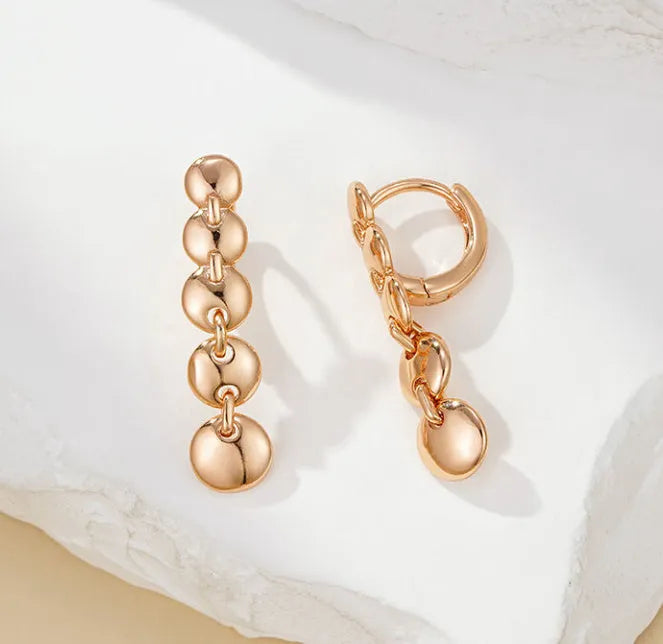 Gold retro long woven copper circle hoop earrings on a white background