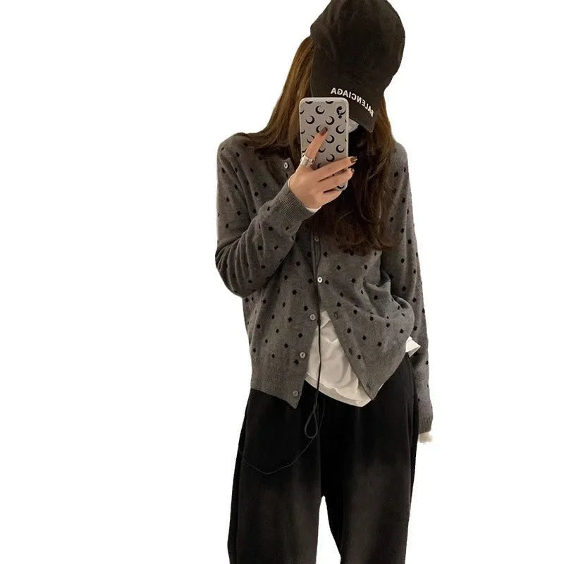 Women's grey and black Korean-style loose knit cardigan with crochet flower detail on the front.
