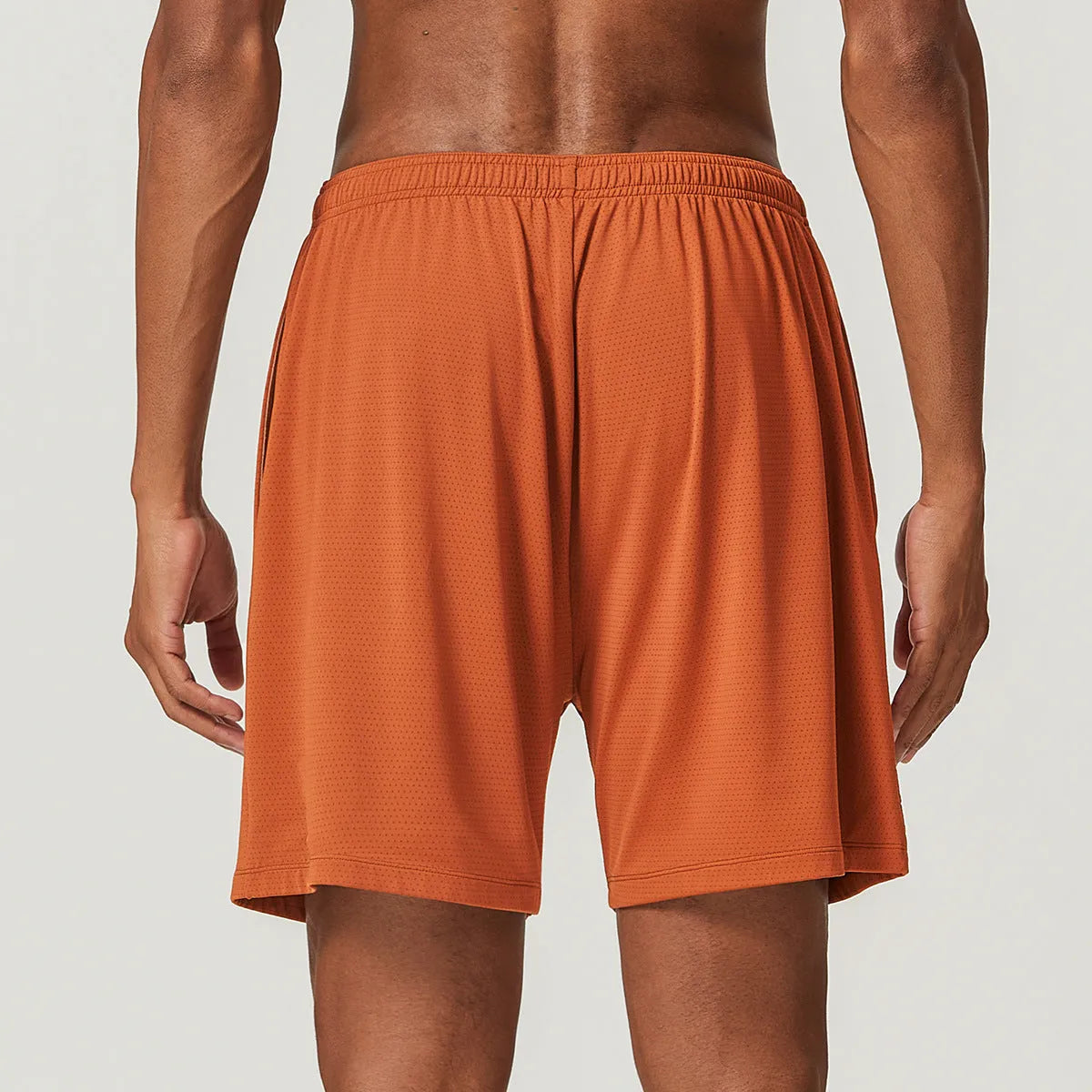 Men's double-layer quick-dry running shorts in brick red colour on a mid-waist fit model.