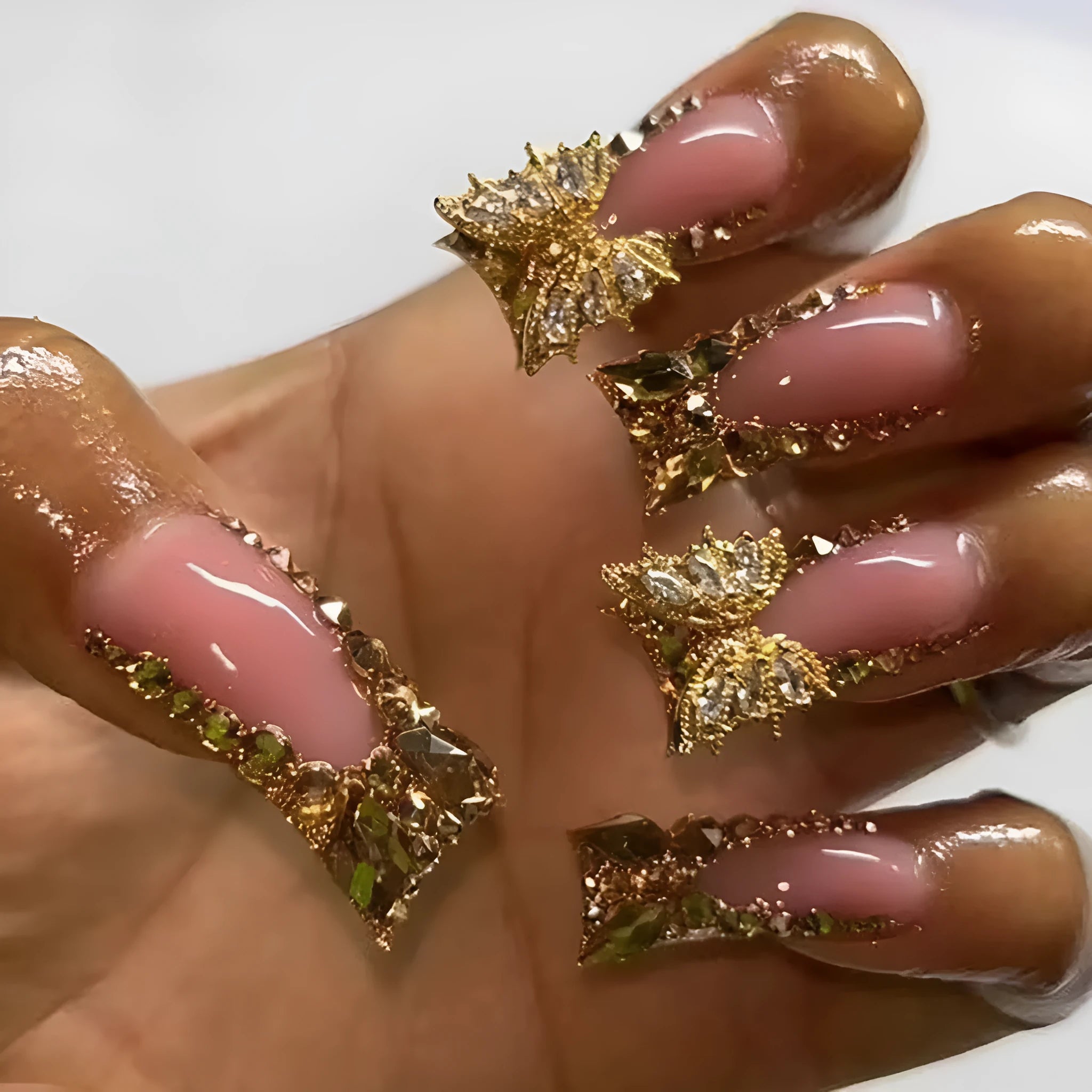 Pack of 24 golden diamond and debris-style butterfly nail stickers with a bottle of glue.