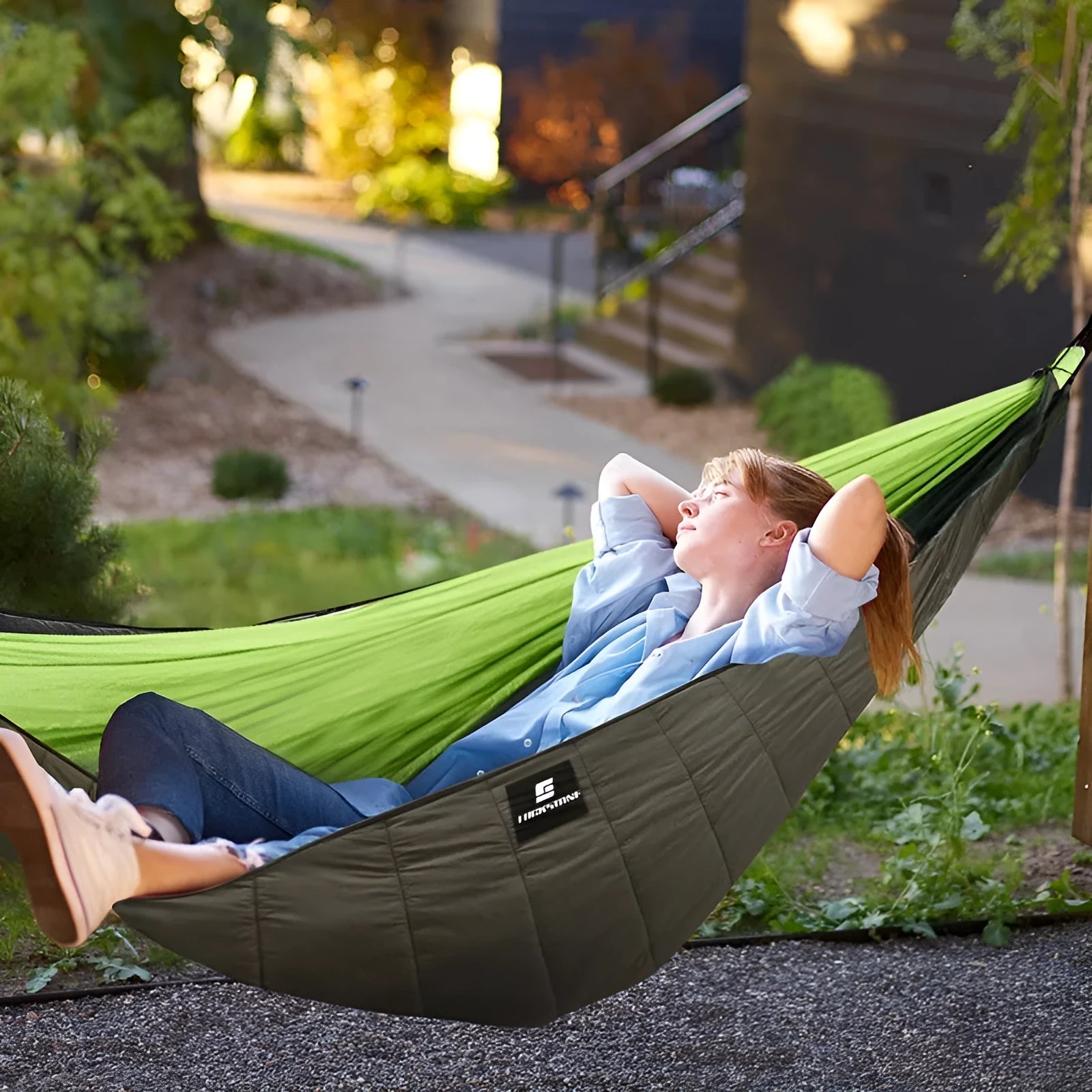 Army green thickened camping hammock sleeping bag with compression bag, shown in an outdoor setting.